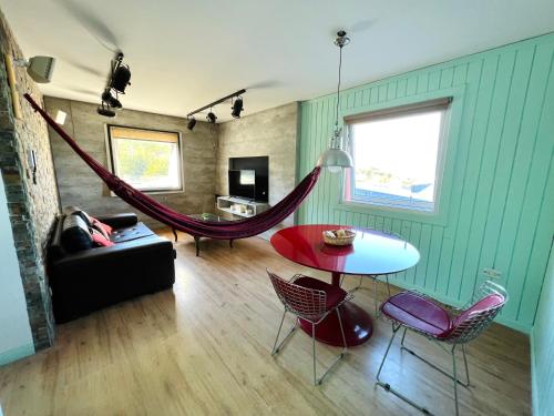 una sala de estar con una hamaca en una habitación en Departamento New Vintage con hermosas vistas a las montañas y al Canal en Ushuaia