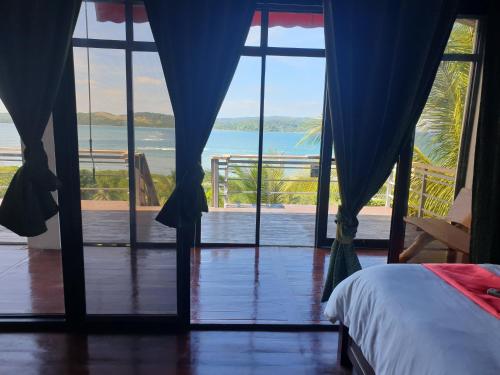 a bedroom with a bed and a view of the ocean at Miley Lodging Restobar in New Busuanga