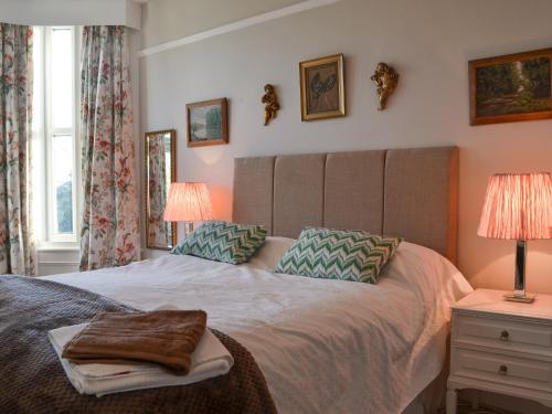 una camera con un grande letto con due lampade di Gaerwen a Criccieth