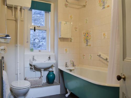 uma casa de banho com um lavatório, uma banheira e um WC. em Gaerwen em Criccieth