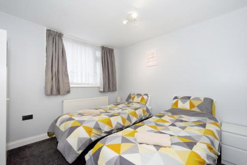 two beds sitting next to each other in a bedroom at Blueville House, Bluewater, 4 Bedroom Houses, Greenhithe, Dartford, Kent-Hosted by Castile Accommodations Ltd in Kent