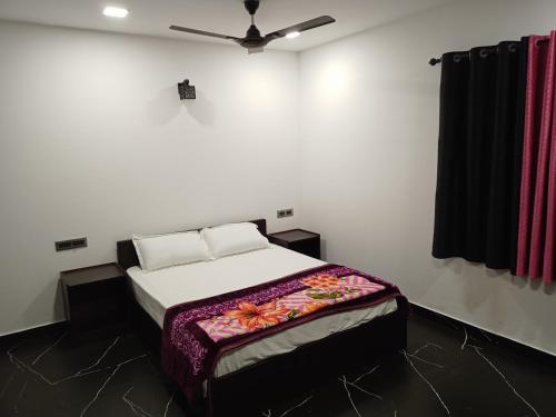 1 dormitorio con 1 cama y ventilador de techo en La casa de Alexa homestay en Idukki