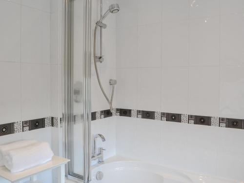 a white bathroom with a shower and a tub at Crescent By The Sea in Newbiggin-by-the-Sea