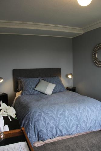 una camera con letto e piumone blu di Rosies Place a Oamaru