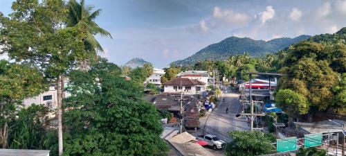 a view of a street in a town with mountains at Ava 2 Budget Hotel Koh Tao in Koh Tao