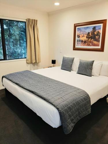 a large bed in a bedroom with a large window at Claremonte Motor Lodge in Hastings