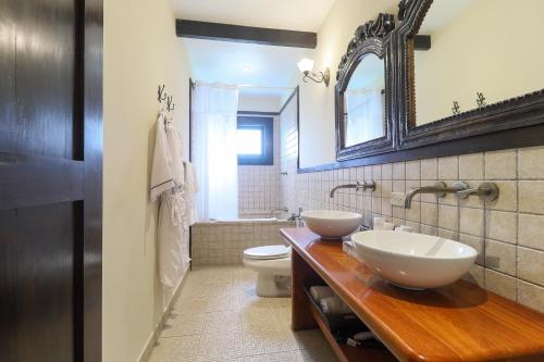a bathroom with two sinks and a toilet and a mirror at The Riverside Inn in Boquete
