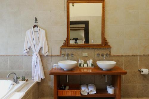 een badkamer met 2 wastafels, een spiegel en een bad bij The Riverside Inn in Boquete