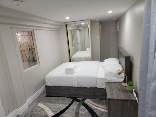 1 dormitorio con 1 cama grande y espejo en Comfy Private Unit, en Toronto