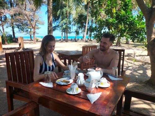 a man and a woman sitting at a table at Hotel Coral Bay in Trincomalee