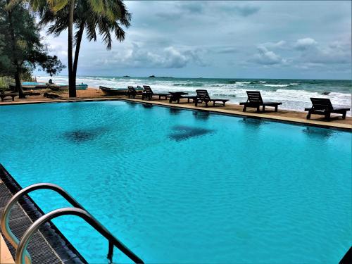 una grande piscina blu accanto all'oceano di Hotel Coral Bay a Trincomalee