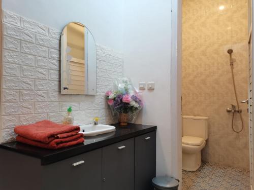 a bathroom with a sink and a mirror and a toilet at Villa Asri in Batu