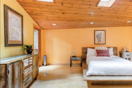 a bedroom with a bed and a wooden ceiling at Sur Grove Big Sur in Big Sur