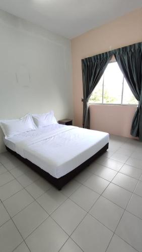 ein weißes Bett in einem Zimmer mit Fenster in der Unterkunft Pusing Holiday Apartment in Pusing