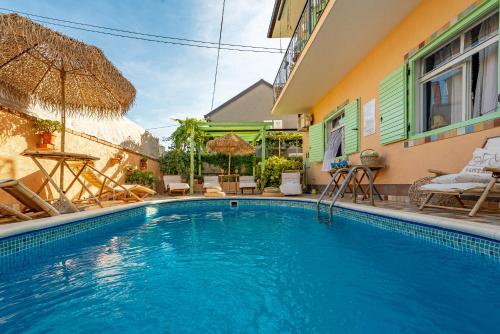 uma piscina em frente a uma casa em Villa Ivano apartmani em Biograd na Moru
