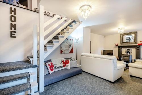 a living room with a staircase and a couch at Bwthyn Y Nant in Dinorwic