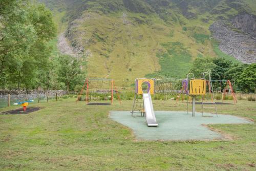 a playground with two play equipment in a park at Bwthyn Y Nant in Dinorwic