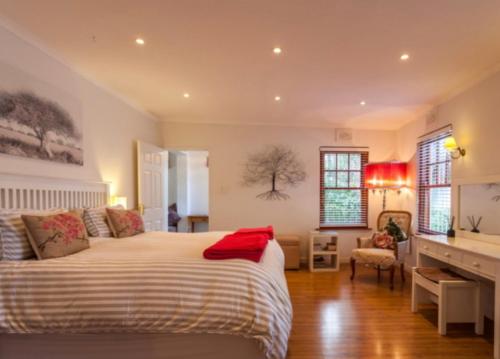 a bedroom with a large bed and a desk in it at Park West Self-catering in Cape Town
