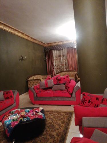 a living room with red furniture and a couch at شقه فندقيه للايجار ثلاث غرف in Cairo
