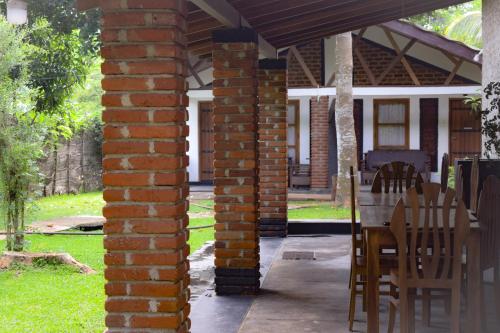 a brick pillar with a table and chairs on a porch at Green Cottage in Anuradhapura