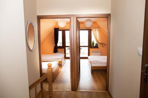 a room with a mirror and a bedroom with two beds at Alpejka - Domek Górski in Idzików