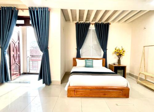 a bedroom with a bed with blue curtains at Hoa De Nhat Hotel- Sân Bay Tân Sơn Nhất in Ho Chi Minh City