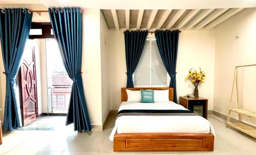a bedroom with a bed with blue curtains at Hoa De Nhat Hotel- Sân Bay Tân Sơn Nhất in Ho Chi Minh City
