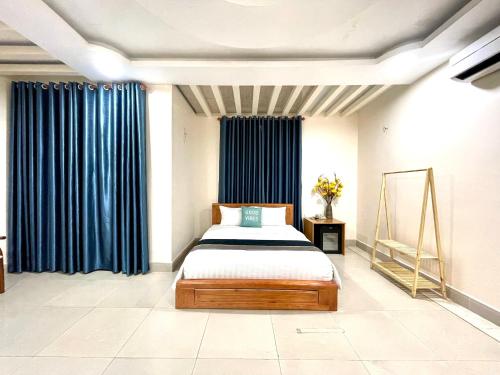 a bedroom with a bed and blue curtains at Hoa De Nhat Hotel- Sân Bay Tân Sơn Nhất in Ho Chi Minh City