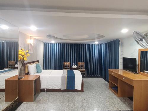 a hotel room with a bed and a flat screen tv at Hoa De Nhat Hotel- Sân Bay Tân Sơn Nhất in Ho Chi Minh City