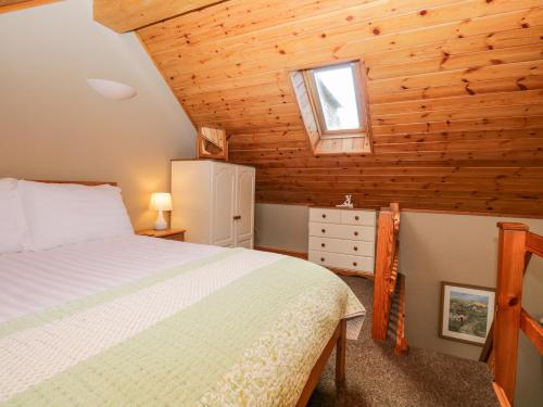 a bedroom with a bed and a window in a cabin at Thimble Cottage in Ulverston