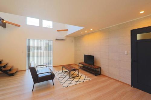 a living room with a chair and a television at ヴィラ ザ・キューブVilla The Cube Fuji view Annovillas in Fujikawaguchiko