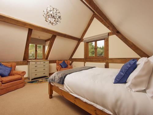 a attic bedroom with a bed and a chair at Keepers Cottage in Picklescott