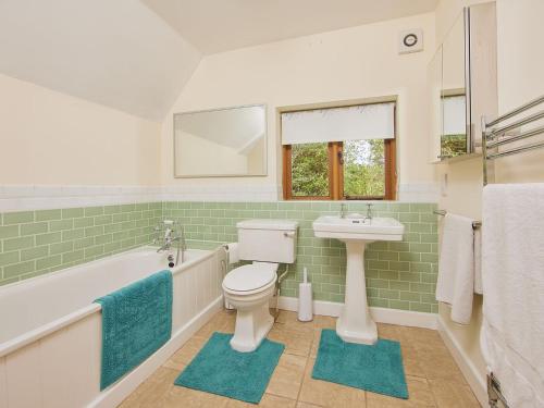 Keepers Cottage في Picklescott: حمام مع مرحاض ومغسلة وحوض استحمام