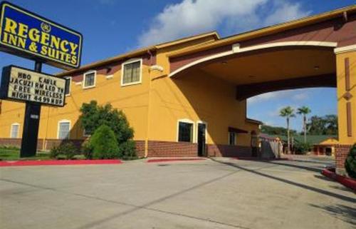 un edificio amarillo con un cartel delante en Regency Inn and Suites Galena Park, en Houston