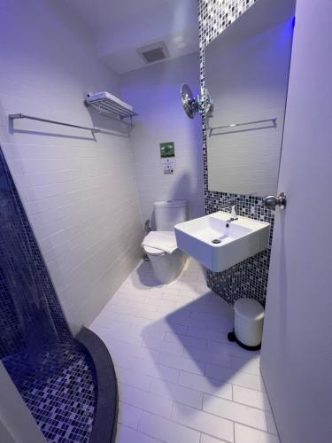 a white bathroom with a sink and a toilet at Stardust Boutique Hotel in Hua Hin