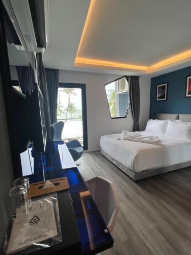 a hotel room with a bed and a desk with a computer at Stardust Boutique Hotel in Hua Hin