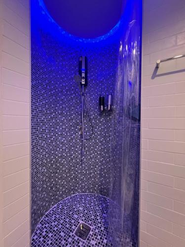 a bathroom with a blue shower with a tub at Stardust Boutique Hotel in Hua Hin