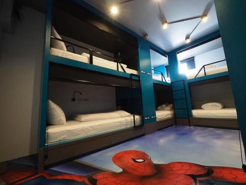a room with three bunk beds with a red spider man on the floor at Stardust Boutique Hotel in Hua Hin