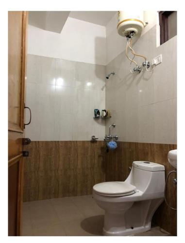 a bathroom with a white toilet and a shower at Yoga House in McLeod Ganj