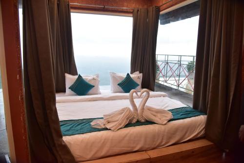 a bed in a room with a large window at Vayalada Valley View Resort in Bālūssheri