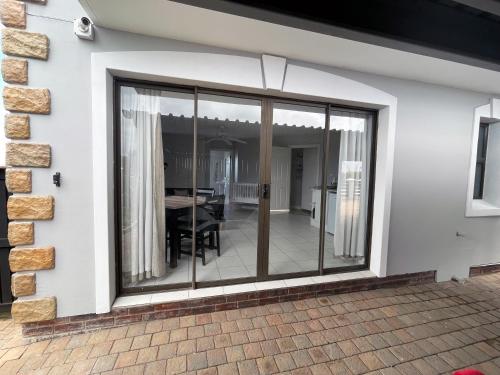 einen Wintergarten mit Glasschiebetüren an einem Haus in der Unterkunft San Lukas Guest Apartment in St Francis Bay