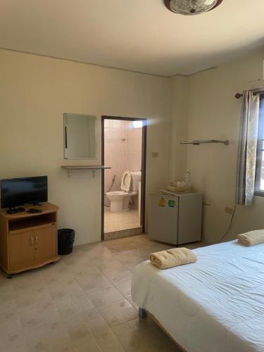um quarto com uma cama e uma casa de banho com um WC em TK Guesthouse em Cha Am