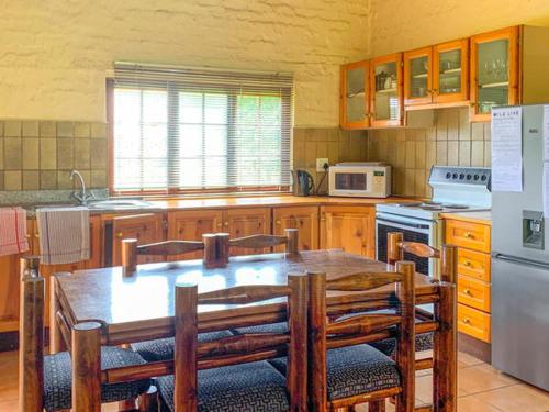 a kitchen with a table and chairs and a refrigerator at Swallowfield Estate 7 & 12 Wits End in Winterton