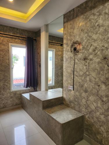 een badkamer met een stenen muur met een bloem op de muur bij Loft House Resort Pattaya in Jomtien Beach