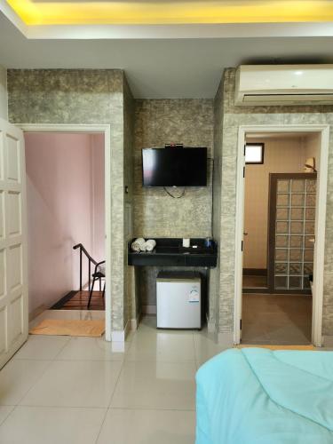 een slaapkamer met een tv aan de muur en een bed bij Loft House Resort Pattaya in Jomtien Beach