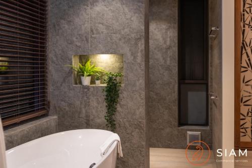 a bathroom with a white tub and plants in it at Jungle Beach Villa in Nathon Bay