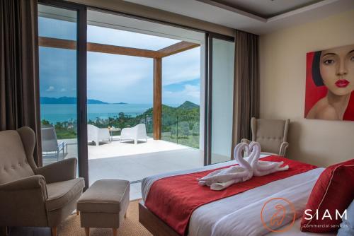 a bedroom with a bed and a painting of a woman at Jungle Beach Villa in Nathon Bay