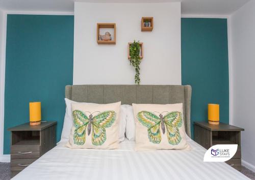 1 dormitorio con 1 cama con mariposas en las almohadas en Luke Stays - Good Station Cottages en Durham