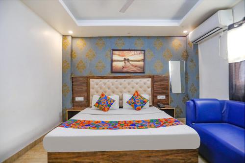 a bedroom with a bed and a blue chair at FabHotel Joy Stick, Sector 11 Noida in Indirapuram