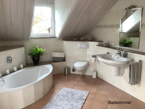 y baño con bañera, aseo y lavamanos. en Wohlfühloase am Michelsberg, en Bad Münstereifel